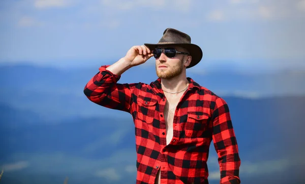 Tiempo dedicado. sexy macho hombre en camisa a cuadros. hombre en el paisaje de montaña. camping y senderismo. aventura de viaje. moda hipster. concepto de campo. granjero en rancho. vaquero en sombrero al aire libre —  Fotos de Stock