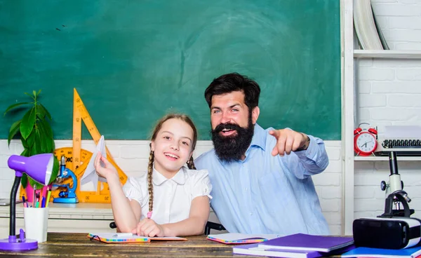 Inspired to work hard. private lesson. back to school. Private teaching. knowledge day. Home schooling. daughter study with father. Teachers day. girl child with bearded teacher man in classroom