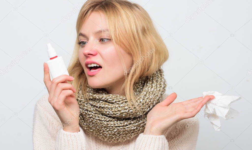 Breathing in gently. Treating common cold or allergic rhinitis. Cute woman nursing nasal cold or allergy. Sick woman spraying medication into nose. Unhealthy girl with runny nose using nasal spray