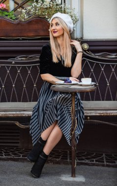 Enfes detaylar kıyafeti mükemmelleştirir. Cafe 'de buluşmak için harika bir kıyafet. Güzel kız sokaktaki kafede dinleniyor. Fransa 'da boş zaman. Güzellik ve moda. Kentsel yaşam tarzı için uygun. Kadınlık kavramı