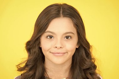 Eğri yumuşak kıvırma maşa. Gevşek ama cilalı görünümlü bukleler. Küçük gülümseyen çocuk kıvırcık saç modeli. Moda trendi. Sıkıca tanımlanmış halkalardan gevşek sahil dalgalarına kadar. Kıvırcık ve mutlu. Mükemmel kıvırcık saç modeli