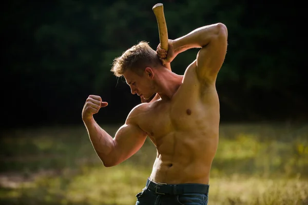 Concepto de fuerza y potencia. Atleta muscular en el bosque. Deporte y fitness. Cuerpo muscular. Hombre guapo sin camisa cuerpo musculoso. Forestal con hacha. Sexy macho torso desnudo. Sobrevivir en la naturaleza salvaje — Foto de Stock