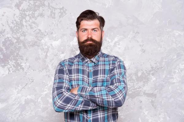 Individual style. Barber salon. Hipster with beard and mustache wear blue shirt. Grooming service concept. Well groomed macho. Handsome hipster man on grey wall background. Bearded man hipster style