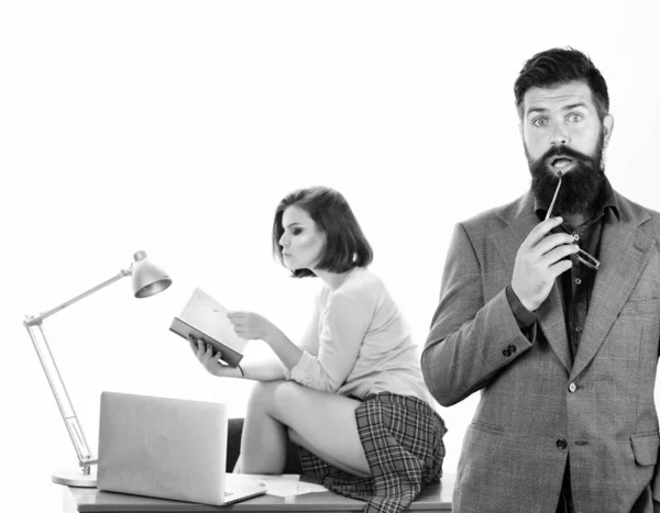 Too smart to fall for this. Bearded man in smart casual wear with sexi coworker. Smart businessman and pretty secretary in office. Smart man holding glasses while sexy woman working in background — Stock Photo, Image