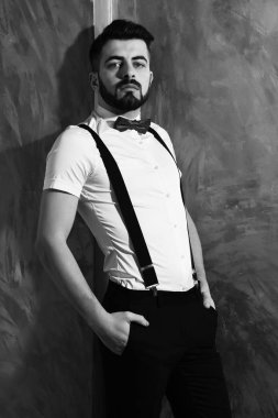 Stüdyo duvarında ciddi bir yüzü olan sakallı bir adam.