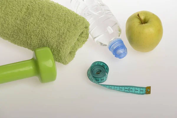 Haltère en couleur vert vif, bouteille d'eau, ruban à mesurer, serviette — Photo