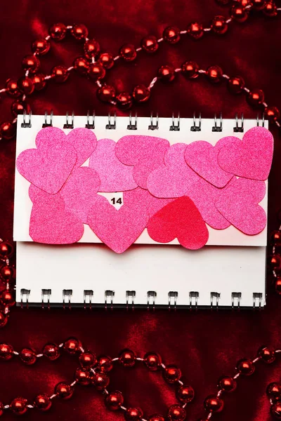 Corações de papel rosa cobrindo página de calendário flip — Fotografia de Stock