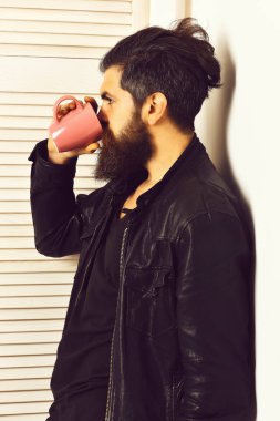 Kafkasyalı vahşi hippi elinde bardak ya da kupa tutuyordu.