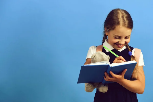 Alumno en uniforme escolar con trenzas y libro —  Fotos de Stock