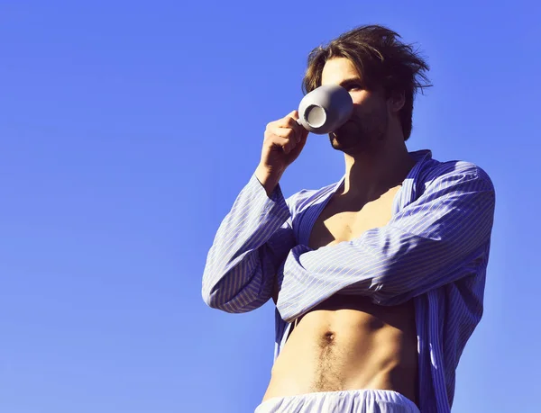 Caucásico macho en azul rayas pijama celebración taza — Foto de Stock