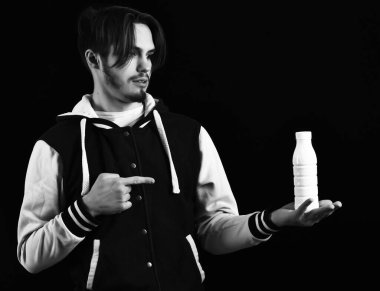 Siyah stüdyo geçmişinde beyzbol ceketli sakallı adam.