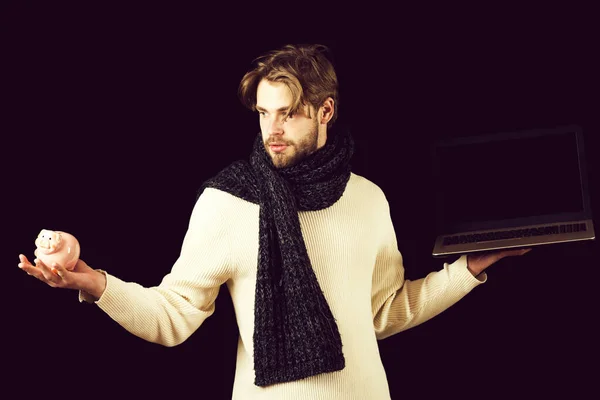 bearded guy with laptop and moneybox on black background