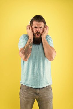 Sakallı adam müzikten hoşlanmaz. Rahatsız edici bir ses. Müzik kablosuz kulaklık dinleyen adam. Ekolayzır ayarları. Korkunç bir ses. Hipster kırık kulaklık müzik gadget dinleyin. Nefret dolu bir şarkı. Müzik tadı