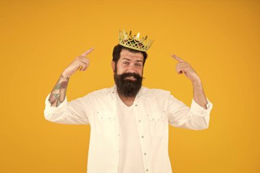 Kral tacı. Kendini sev. Tatil karnavalı kutlaması. Vahşi adam prens sarı arka plan. Partinin kralı. Bencil bencil adam. Süperstar konsepti. Kraliyet statüsü. Kendini beğenmişlik.