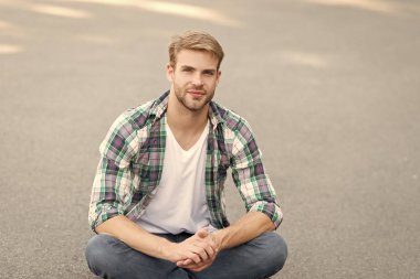 Sakin ol. Yakışıklı, kareli gömlek. Erkek modası. Öğrenci yolda dinleniyor. Dışarıdaki maço adam. Sokak tarzı. Yerinizde kalın. Kaygısız öğrenci. Boş zaman harcamak. yaz modası