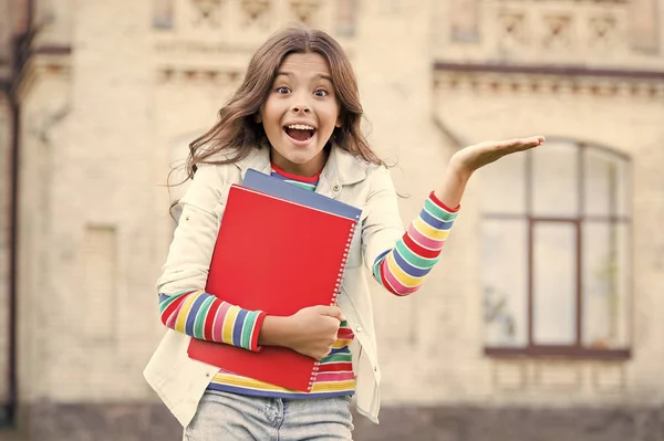 Educación escolar. Educación moderna. Niña sonriente estudiante de la escuela sostiene libros de texto para estudiar. Educación para niños dotados. Alumno exitoso. Curso extra para un aprendizaje más profundo — Foto de Stock