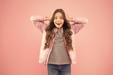 Vay canına! Sonbahar sürprizi. Pembe arka planda sürpriz bir çocuk. Sonbahar tarzında şaşırmış bir çocuk. Küçük kız uzun esmer saçlı ve şaşkın bakışlı. Şaşırdım ve şok oldum.