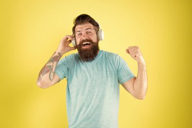 Sakallı adam müzik kablosuz gadget dinlemek. Hipster modern kablosuz kulaklıklar kullanarak mutlu. Kablosuz yayın özgürlüğü size benzersizdir. Kablosuz kulaklıklar temiz ses sunar. Modern teknoloji