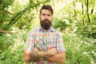 Yaz stili. Sakallı adam doğal manzara üzerinde rahat bir tarzda kollarını tutarak. Brutal hipster moda bıyık ve sakal saç stili açık giyiyor. Kişisel tarzıyla