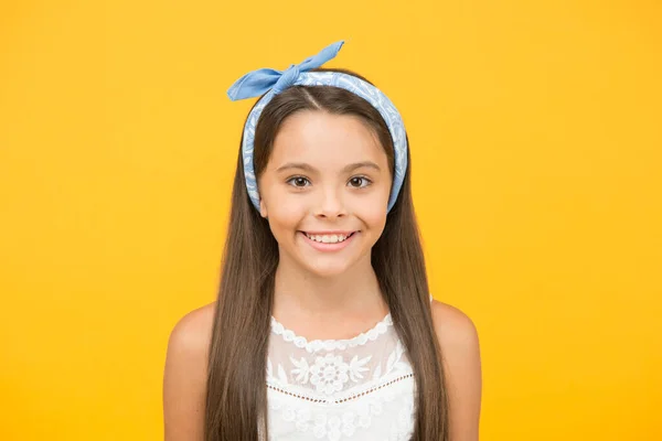 Precioso cada momento. Fondo amarillo niña feliz. Niño pequeño con linda sonrisa. Los niños pequeños llevan el pelo largo y moreno. Salón de belleza. Moda y estilo. El cuidado infantil y la infancia. Día de los niños —  Fotos de Stock