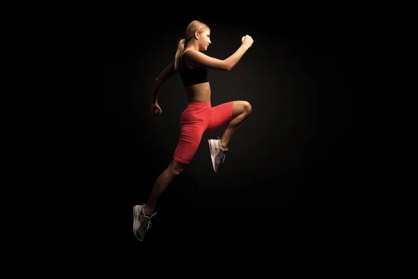 Hayat harekettir. Kadın sporcu harika sonuçlar elde eder. Daha hızlı koş. Hızlı eğitim rehberi. Koşu hızını arttır. Siyah arka planda bir kız koşucu. Spor yaşam tarzı ve sağlık konsepti. Başlangıç koşusu — Stok fotoğraf