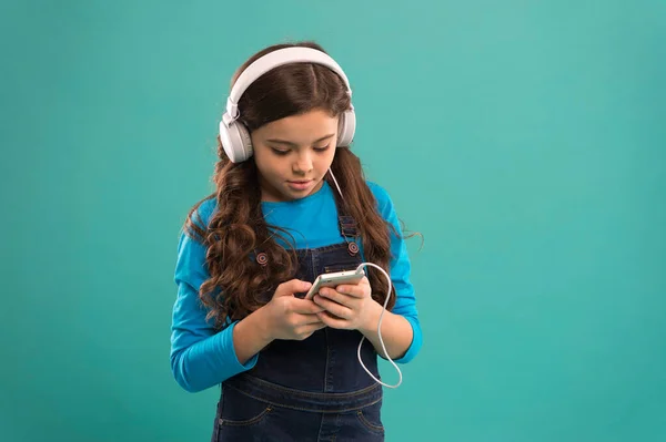 Odpowiedz na maila. małe dziecko zrobić listę odtwarzania na smartfonie. Mała dziewczynka używa odtwarzacza mp3. studiować we współczesnym życiu. Dziewczyna używa urządzenia cyfrowego. Zwykła moda dla dzieci. dziecko długie włosy słuchać muzyki w słuchawkach — Zdjęcie stockowe