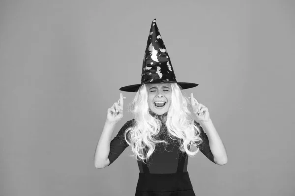 A remény varázslat működik. Boszorkányjelmezes kisgyerek. Halloween buli. Egy kislány fekete boszorkány kalapban. Őszi szünet. Csatlakozz az ünnepléshez. Varázslat. Kis boszi ősz hajjal. Varázsló vagy bűvész — Stock Fotó