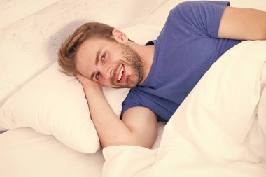 Büyük bir zevk yaşıyor. Sabah uyandıktan sonra gülümseyen bekar bir adam. Evde yatakta yatan bekar bir insan. Yatak odasında dinlenen bekar bir adam. Mutlu bekar bir hayatın tadını çıkarmak