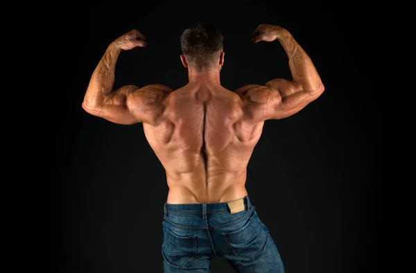 Bodybuilder perfect shape rear view. Strong bodybuilder flexing arms muscles black background. Fit bodybuilder showing muscular body. Professional coach demonstrate achievements. Exercises for back — Stock Photo, Image