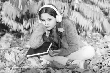 Kendi kendine eğitim kavramı. Çocuk okumayı sever. Görsel ve işitsel bilgiler. Öğrenci kız çalışması. Her gün çalış. Sonbahar günü kitap okuyan bir kız. Küçük çocuk arka bahçede öğrenmenin tadını çıkarıyor. Çocuk kitapla çalışıyor.