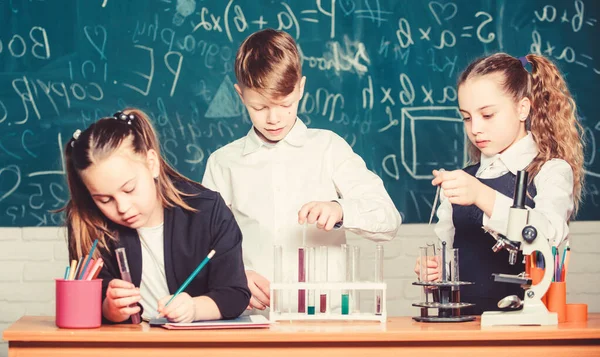 Estudiantes haciendo experimentos de biología con microscopio. Niños pequeños en el laboratorio. Microscopio químico. Microscopio de laboratorio. Estudiando duro para tener buenas notas. Niños pequeños aprendiendo química en el laboratorio escolar —  Fotos de Stock