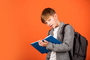 Final sınavı. Küçük çocuk kahverengi arka plan sınavına giriyor. Küçük çocuk mavi deftere yazıyor. Yazılı sınav. Sınav kağıdı. İnceleme ve test. Okul ve eğitim, kopyalama alanı