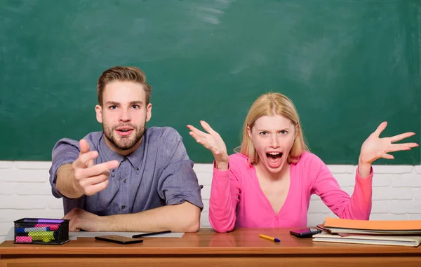 Wondering about result. Studying in college or university. Couple friends students studying university. Surprising answer. Studying hard. How is it possible. Guy and girl sit at desk in classroom