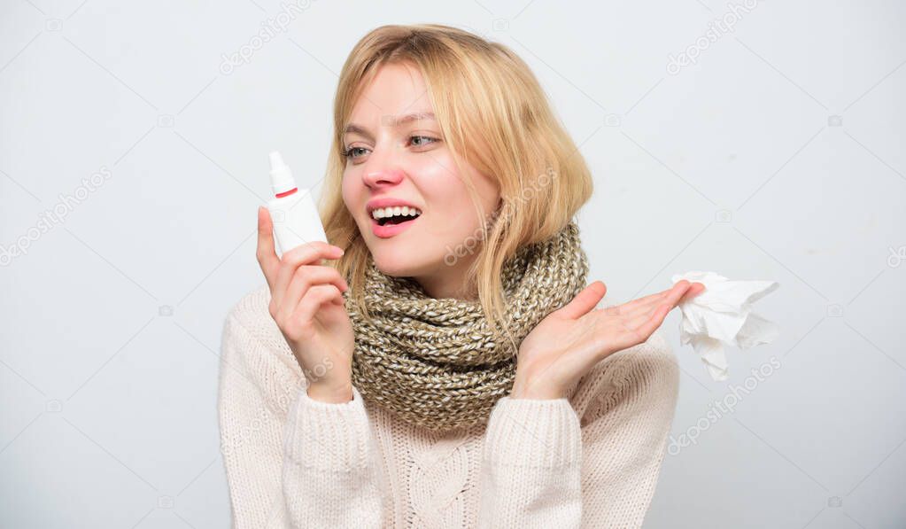 Happy to breathe again. Sick woman spraying medication into nose. Treating common cold or allergic rhinitis. Cute woman nursing nasal cold or allergy. Unhealthy girl with runny nose using nasal spray