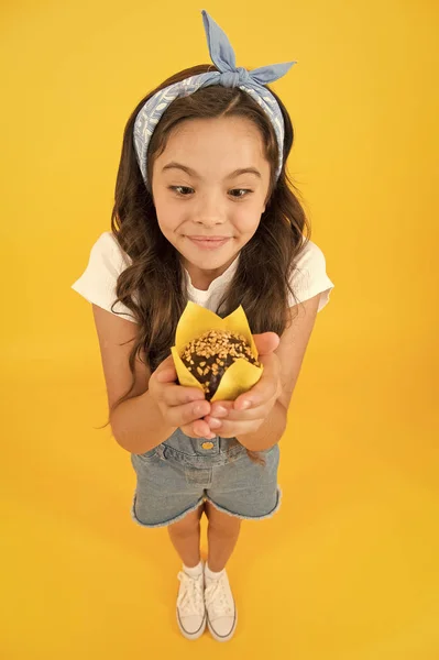 Gluten free recipe. Delicious cupcake. Little child with muffin on yellow background. Treat someone with sweets. Yummy cupcake. Homemade muffin. Sweet tooth concept. Kid girl hold appetizing muffin