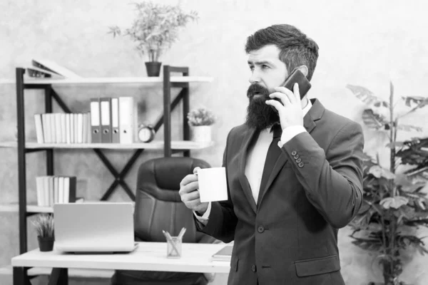 Adam sakallı işadamı fincan ve akıllı telefon tutun. Kahve başarılı bir müzakere sözüdür. Kafein bağımlısı. Mobil arama. Güne kahveyle başlayın. Kahve rahatlatıcı mola. Patron enerji içeceği zevk — Stok fotoğraf