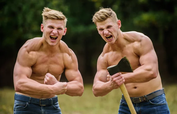 Çifte güç. Erkeklik ve vahşet kavramı. Seksi kaslı erkekler vahşi görünürler. Sporda başarıya ulaşmak. Mezomorf. Baltalı kaslı ikizler. Atletik adam balta kullanıyor. — Stok fotoğraf