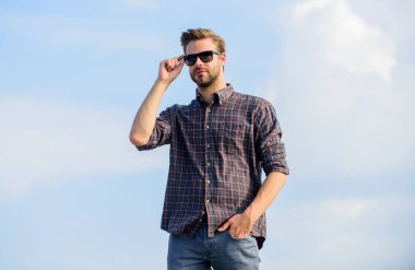 Göz sağlığı. Modaya uygun güneş gözlükleri. Moda güneş gözlüklü hippi. Ultraviyole koruma kavramı. Erkek gözlüklü model açık havada mavi gökyüzü arka planı. Yakışıklı adam güneş gözlüğü takıyor. Mükemmel görüş