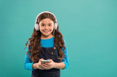 Küçük kız müzik dinler modern kulaklıklar ve akıllı telefon. Çevrimiçi eğlence. Bedava müzik uygulamaları. Bedavaya dinle. Müzik hesabı aboneliği al. Müzik konseptinin tadını çıkar Mükemmel sesin tadını çıkar