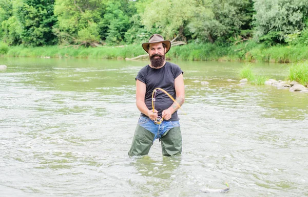 Pro Pesca. pescatore barbuto in acqua. hobby e attività sportive. Pothunter. pescatore con canna da pesca. uomo maturo pesca a mosca. uomo cattura il pesce. weekend estivo. Grande gioco di pesca — Foto Stock