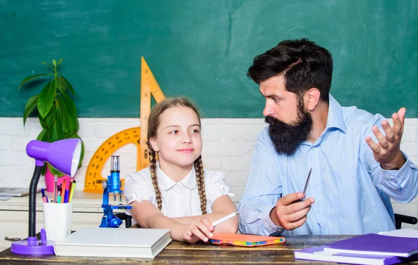 Such an interesting book. father and daughter study in classroom. back to school. math geometry. biology chemistry lesson. education and knowledge. bearded man teacher with small girl in classroom — Stock Photo, Image