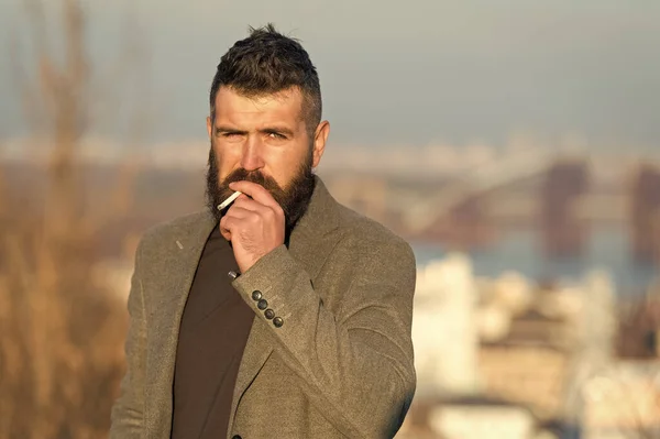 Smoking devices concept. Bearded hipster smoking outdoors. Device hide conceal smell of smoke. Handsome man smoke flying out of mouth. Cigarette tobacco harmful health influence. Smoking aesthetics — Stock Photo, Image