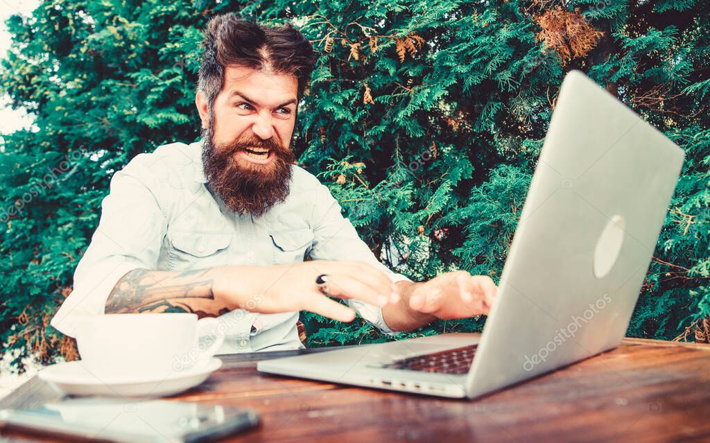 Bearded man freelance worker. Remote job. Freelance professional occupation. Hipster busy with freelance. Wifi and laptop. Slow internet irritating. Drink coffee and work faster. Deadline is coming