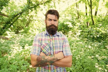 Eko yaşam tarzı. Çevreile birleşmiş. Yakışıklı oduncu. Adam sakallı hipster yeşil ağaçlar arka plan. Adam yaz doğada dinlenmek. Yaz ormanında erkek sakalı ve bıyığı. Yaz tatili konsepti