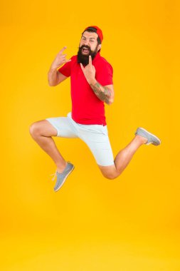 Heyecanlı sakallı adam zıplıyor. Enerji dolu. Aceleci hareket. Spor ve forma adanmıştır. Aktif koşucu hareket halinde. Her zaman hareket halinde. Başarı ve mutluluk