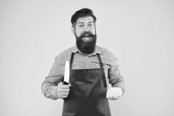 Concept de vendeur. Fromagerie. Un barbu au tablier tient du fromage. Profession du personnel du magasin. Achète du fromage. Produit gastronomique. Produits laitiers dérivés du lait. Achats en ligne. Alimentation et nutrition — Photo