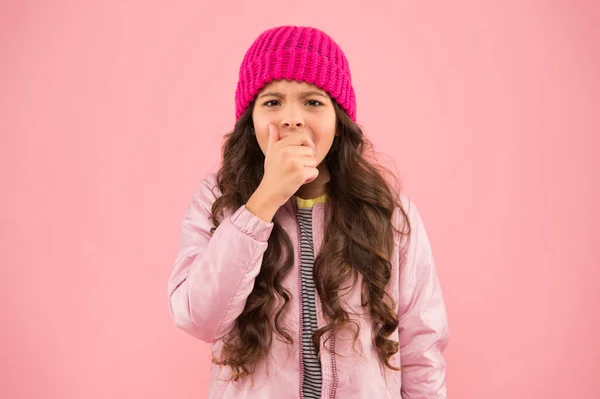 Маленькая девочка подхватила кашель. Нет гриппа этой зимой. носить теплую одежду в холодное время года. зимние каникулы. маленький розовый фон. Детская мода. детская вязаная шляпа и пиджак. Зимний грипп — стоковое фото