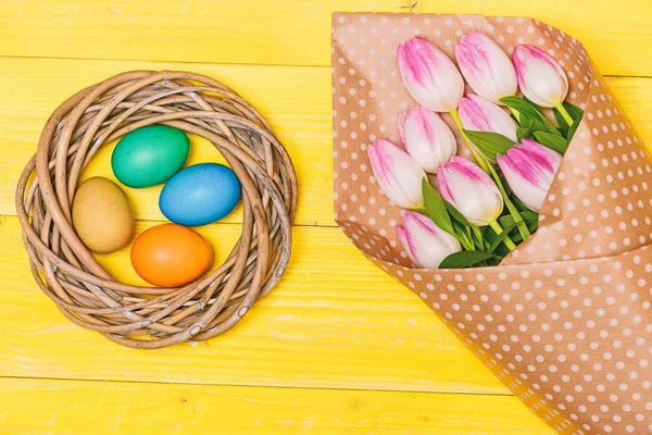 Renkli yumurta ve buket taze Lale çiçek sarı arka plan üzerinde görünümü top. Bahar tatili. Gelenek Paskalya kutlamak. Mutlu Paskalya sezon. Paskalya geliyor. Paskalya yumurtası toplama. Bahar vibes — Stok fotoğraf