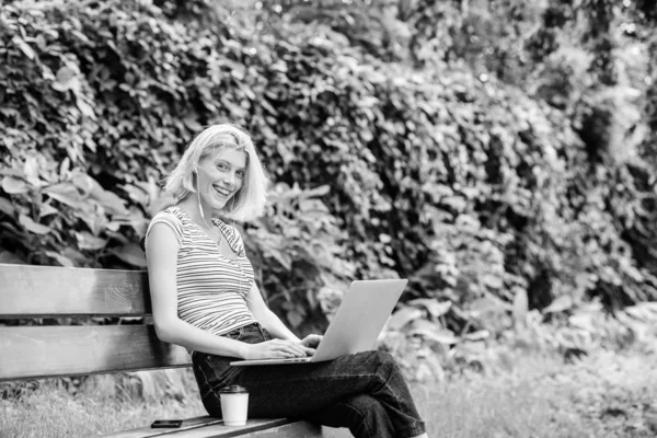 Девушка работает с ноутбуком в парке. Причины, по которым ты должен вынести свою работу наружу. Работа в летнем парке. Природа имеет важное значение для благополучия и способности быть продуктивным и высокофункциональным на работе — стоковое фото