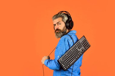 Çevrimiçi Video Oyunu. Siber Şampiyonluk. Çevik iş. İnternetten müzik indiriyorum. Sakallı adam kulaklıkları ve klavyesi. Profesyonel Oyuncu Arcade bilgisayar oyunu oynuyor. çevrimiçi sohbet